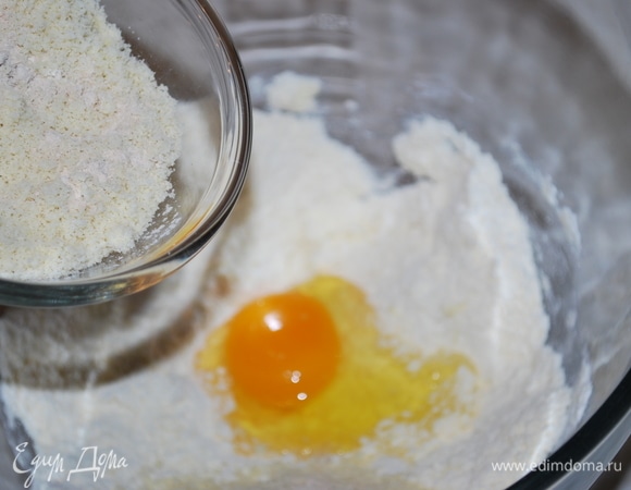 Добавьте одно яйцо, сахарную пудру и миндальную муку. Замесите тесто.