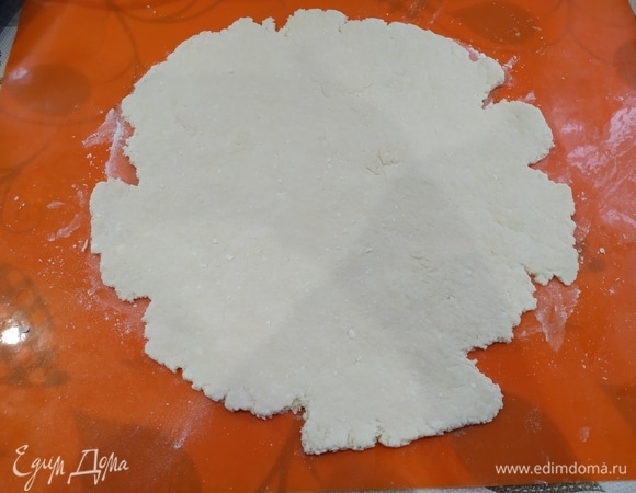 Делим тесто на две части и раскатываем каждую в круг диаметром примерно 23–25 см. Рабочую поверхность посыпайте мукой.