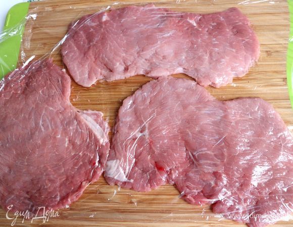 Накрыть пищевой пленкой, отбить. Должны получиться куски толщиной примерно 4 мм. Дать им полежать под пленкой минут 10–15. Снять пленку, посолить, поперчить.