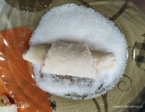 Каждый рогалик обваливаем в сахаре и выкладываем на противень, застеленный бумагой.