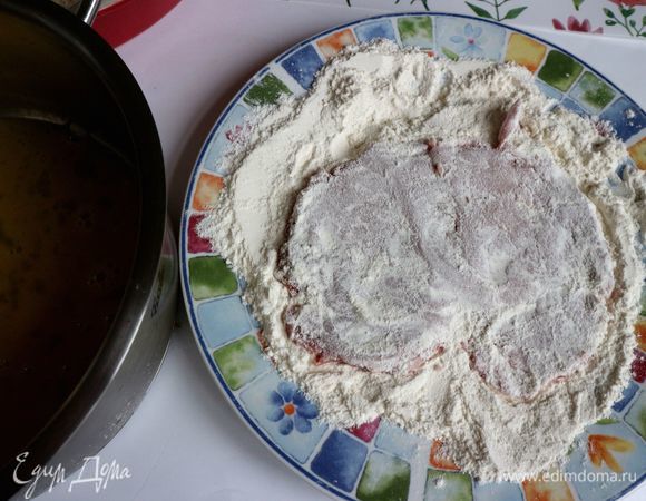 Шницели поочередно опускать сначала в тарелку с мукой, излишек муки стряхивать.