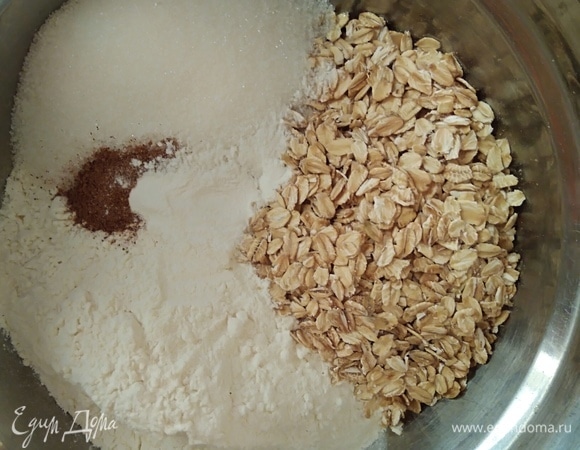 В одной миске соединить сухие ингредиенты: муку, хлопья, сахар, разрыхлитель, корицу. Хлопья лучше взять не быстрого приготовления, а обычные.