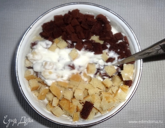 В сметанный крем выложить кубики светлого и темного коржа, перемешать.