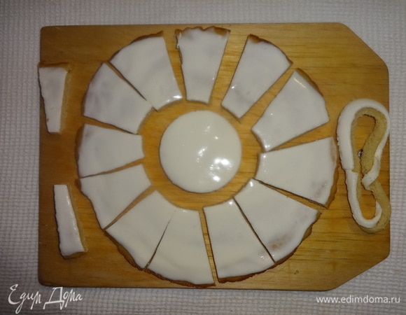 Достать из холодильника светлый корж, смазанный кремом. Крем уже хорошо застыл. С помощью стаканов разного диаметра вырезать посередине коржа круг и тонкое кольцо. Тонкое кольцо убрать. Широкое кольцо разрезать на части (это лепестки «ромашки»). Я вырезала еще 2 узких части, чтобы при выкладывании на крем был виден просвет. Один из лепестков также не понадобился.