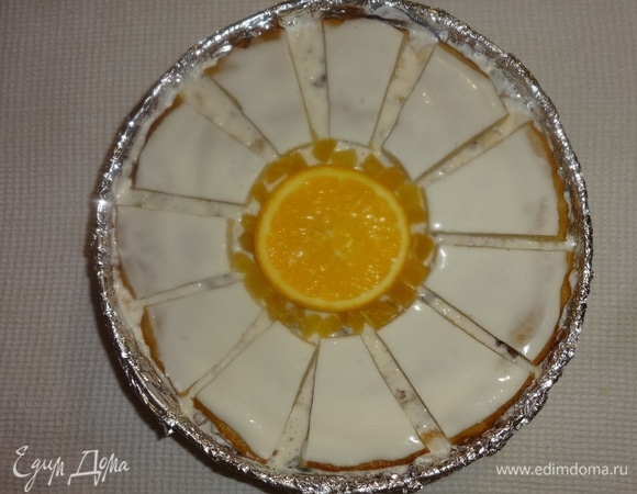 В форму выложить середину «ромашки», на нее положить кружок апельсина. Далее по кругу выложить лепестки. Зазор между серединой и лепестками заполнить цукатами желтого цвета. Поставить торт в холодильник для застывания на несколько часов. Хотя крем начал застывать уже при сборке торта.
