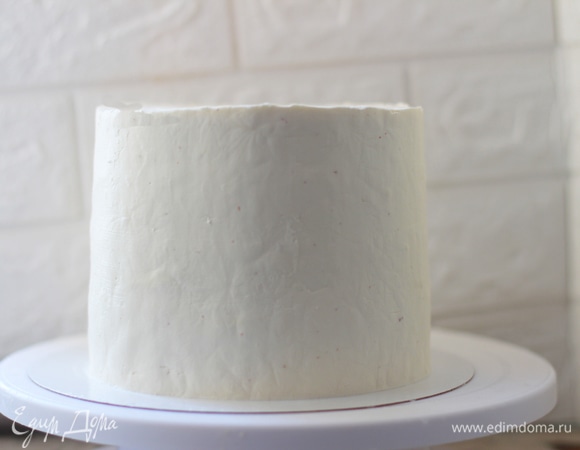 Отделка. Сыр вынуть за 20 минут до приготовления крема. В дежу положить сыр, пудру и сливки, взбить 3 минуты до полного соединения. Далее крем вымешать лопаткой для избавления от пузырей воздуха. Заготовку вынуть из формы, взять немного крема и сделать черновую обмазку торта. Это необходимый этап. Таким образом вы заполняете пустоты, слегка выравниваете корж и собираете кремом крошки от бисквита с боков. Иначе при чистовой сборке они будут перемешиваться с кремом и распределяться по всех поверхности. Поставить торт в холод на полчаса, крем за это время хорошо схватится, и выравнивать будет легче. Уложить крем в мешок (или просто наносить спатулой) и равномерно нанести по всей поверхности торта. Выровнять с помощью кондитерского шпателя или просто школьным уголком. Для качественного выравнивания нужен поворотный столик и навык работы с кремом.