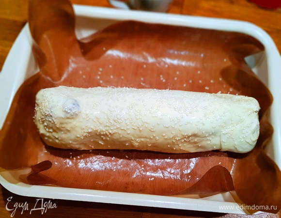 Укрываем тестом вырезку, получается вот такой рулет. Смазываем поверхность теста яйцом и посыпаем кунжутом.