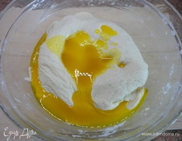 Выливаем масло в тесто и начинаем вымешивать. Вначале сложно, но немного терпения — и все получится. В процессе замеса тесто периодически складывается и отбивается о стол.