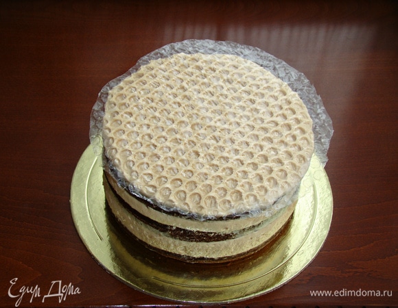 Часть оставленного крема нанести равномерно на верх торта и сверху уложить круг из упаковочной пленки (тщательно промыть и высушить заранее). Пленку слегка вдавить, чтобы в креме проявился рисунок наших сот. Торт снова поставить в холодильник на полчаса.