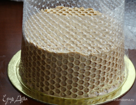 Затем обмазать бока торта оставшимся кремом и обернуть пузырчатой пленкой, слегка вдавливая ее, чтобы образовался красивый рисунок в виде сот. Торт поставить в холодильник на несколько часов.