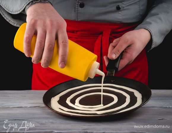 Выливайте тесто на сковороду при помощи бутылки в виде ажурной сетки, обжаривая каждый блин с двух сторон до золотистой корочки.