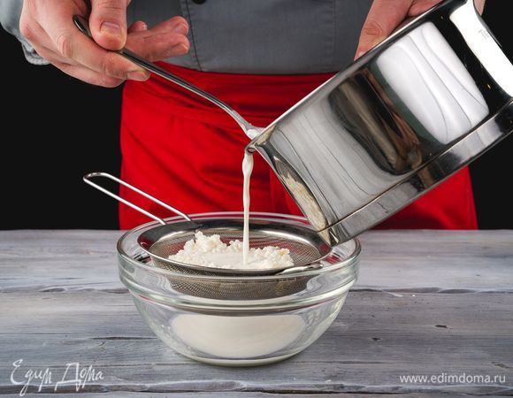 Как только масса створожится, снимите с огня. Важно — масса не должна кипеть. Процедите творог через сито и уберите под гнет на пару часов.
