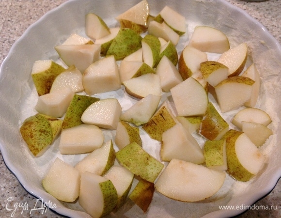 Духовку включить на 150°C. Помыть, нарезать груши (не чистить от кожуры). В форме для выпечки сделать «французскую рубашку». Сливочным маслом слегка смазать и припорошить мукой. Выложить груши в форму.