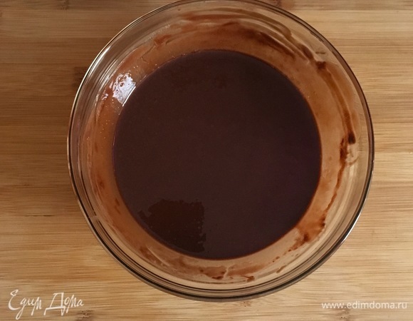Сливочное масло соедините с темным шоколадом и растопите на водяной бане до полного объединения. Охладите массу в течение 3–5 минут. Разогрейте духовку до 180°C. Застелите форму для выпечки бумагой и слегка смажьте сливочным маслом.