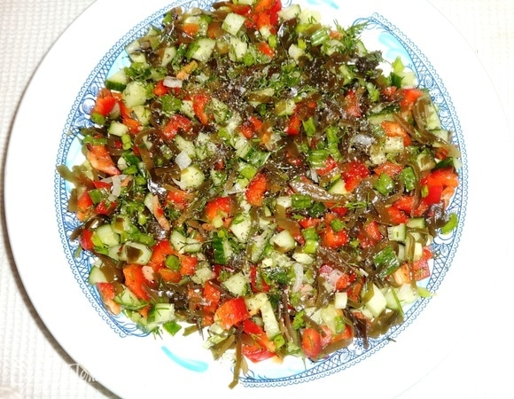 Соединить нарезанные овощи, зелень, морскую капусту, немного посолить, поперчить, перемешать и выложить в салатник. Из отложенного кусочка перца вырезать с помощью выемки маленькие сердечки.