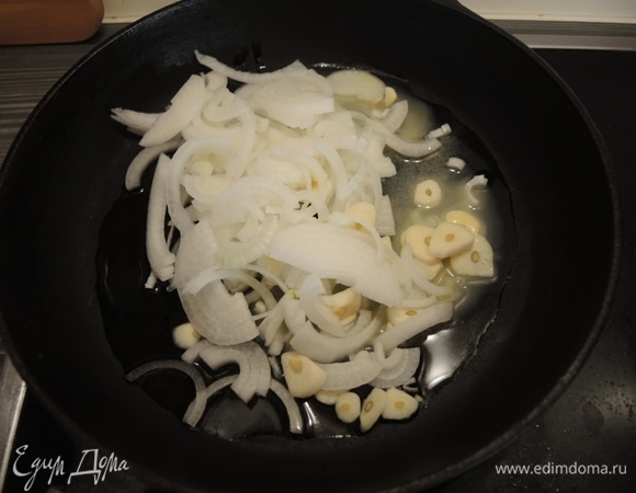 Лук режем полукольцами и кладем в разогретое масло, туда же отправляем нарезанный чеснок.