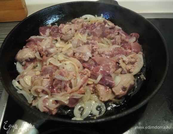 Затем к луку с чесноком добавляем крупно нарезанную куриную печень. Жарим вместе 5 минут.