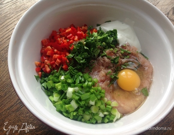 Охлажденный фарш куриного филе хорошо взбиваю. Нарезаю мелко перец, лук, петрушку, вбиваю яйцо, кладу сметану, сливки, чеснок. Хорошо вымешиваю.