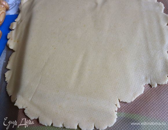 Накрыть бумагой для выпечки, раскатать от центра к краям.