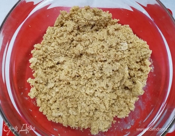 Хорошо перемешайте печенье с маслом. Получится «влажный песок».