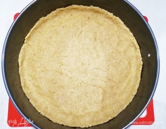 Плотно утрамбуйте основу в разъемную форму. У меня форма диаметром 22 см. Уберите форму с основой в холодильник, пока готовите начинку.