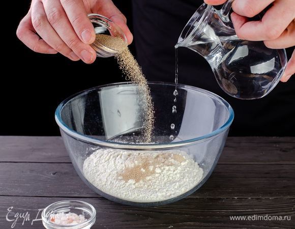 Смешайте муку, соль и дрожжи, влейте воду.