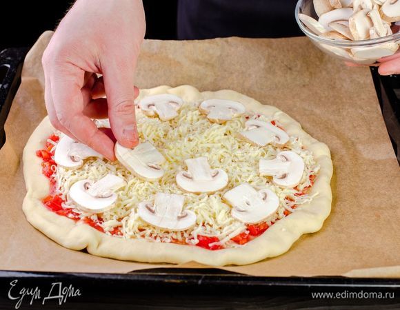 Раскатайте тесто в круг, выложите на него помидоры с маслом и солью, сыр и грибы.