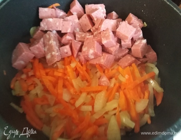 Лук с морковью обжарить на растительном масле. Добавить нарезанную колбасу. Обжарить. Картофель нарезать.
