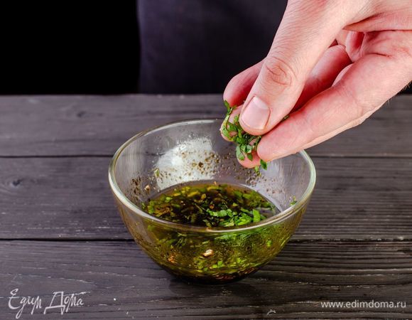 Добавьте в заправку чеснок и измельченную зелень.