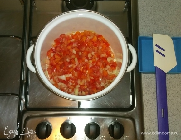 Добавляем оливковое масло в кастрюлю, в которой будем варить суп. После чего выкладываем туда лук, помидор и перец. Перемешиваем все вместе и ставим на маленькую конфорку на средний огонь минут на 5, чтобы овощи чуть-чуть дали сок.