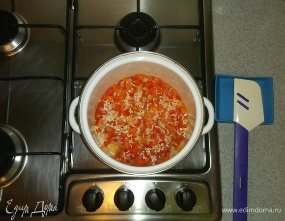 После чего добавляем к овощам рис. Опять все перемешиваем и тушим овощи с рисом на среднем огне еще минут 5.