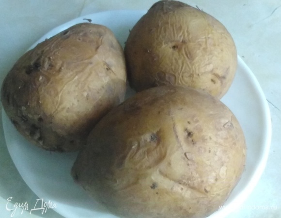 Отварить картофель в мундире. Лучше это сделать заранее, чтобы картофель был полностью остужен и высушен. Так при нарезке он не будет рассыпаться.