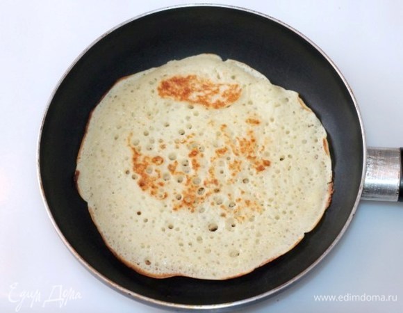 Как только тесто поднимется, выпекать блины на раскаленной и смазанной топленым маслом сковороде.