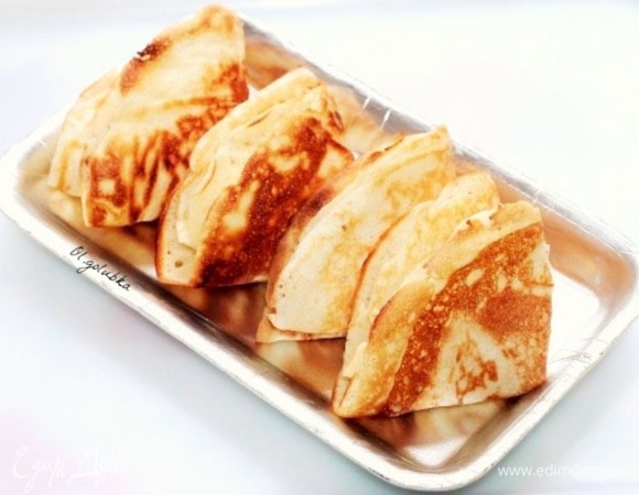 Каждый готовый блин кладем на тарелку, смазываем сливочным маслом. Складываем блины треугольником, держим под крышкой, чтобы не остывали.