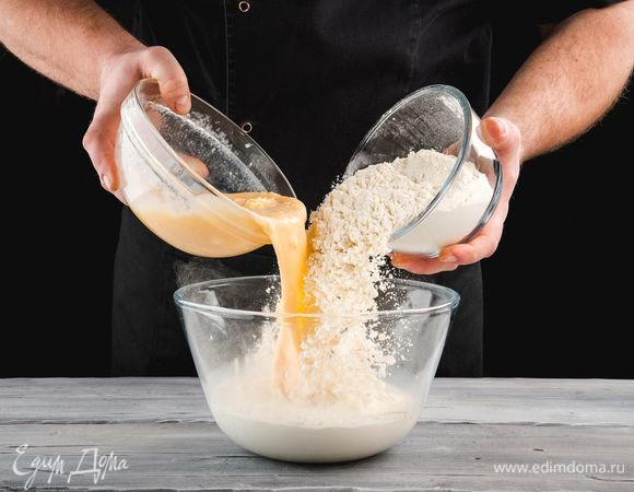 В опару добавьте яичную смесь и постепенно частями всыпьте муку. Хорошо вымешивайте тесто, чтобы не было комочков.