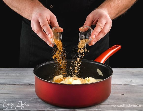 Тем временем промойте яблоки, очистите от кожуры, удалите сердцевину, нарежьте яблоки тонкими ломтиками. Выложите в сковородку, засыпанные сахаром и добавьте корицу и имбирь.