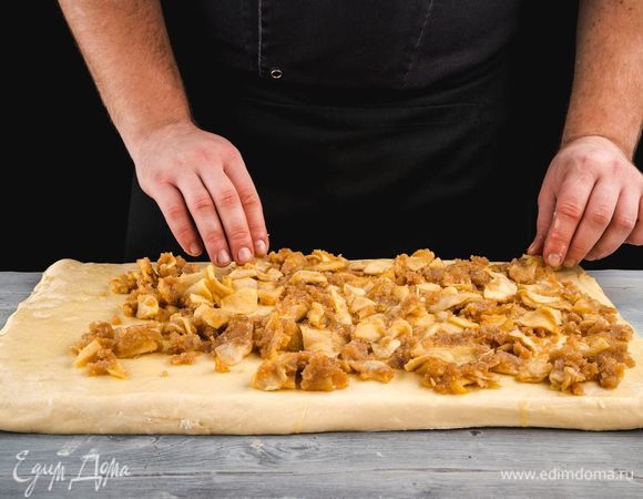 Из теста раскатайте прямоугольный пласт, выложите его на противень. Смажьте растопленным маслом и выложите начинку ровным слоем.