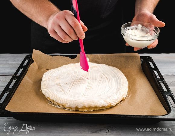 Смажьте заготовку сметаной и уберите в духовку на 30 минут. Разогрев духовку до 180°С.