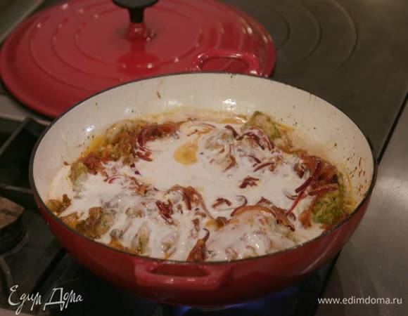 В сковороду, где жарился лук, выложить куриные бедра в маринаде и обжаривать с одной стороны до появления золотистой корочки, затем перевернуть, добавить лук, полить все кокосовым молоком, накрыть крышкой и готовить на небольшом огне около 25 минут.