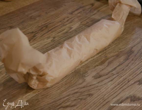 Завернуть рулет в бумагу для выпечки и отправить в морозильник на 10 минут.