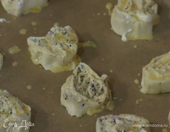 Желток размешать с молоком и солью и смазать кусочки рулета.