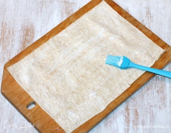 Разложить лист лаваша (66х46 см) на разделочной доске и разделить его пополам (33х23 см). Смазать лаваш домашним майонезом. Болгарский перец запечь в духовке и удалить семя и шкурку.