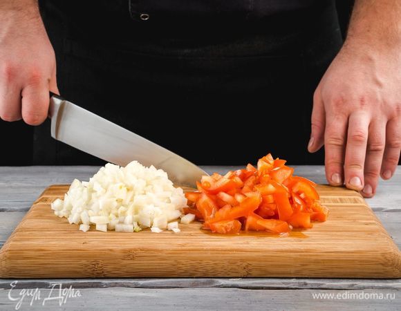 Очистите и измельчите лук. Помидоры нарежьте кубиками.