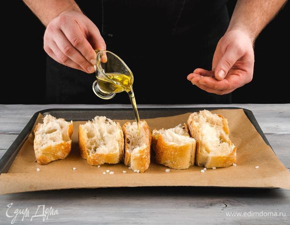 Пока варится суп, приготовьте сухарики. Нарежьте белый хлеб крупными ломтиками, выложите на противень. Сбрызните хлеб оливковым маслом и посолите слегка. Запекайте до золотистого цвета при 180°С.