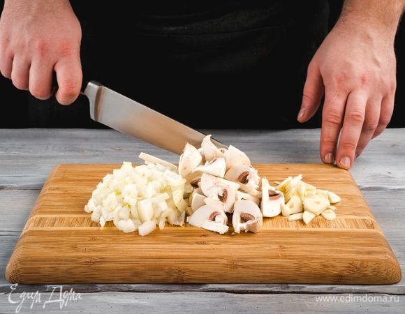 Очистите лук и чеснок, измельчите. Промойте грибы и нарежьте кусочками.