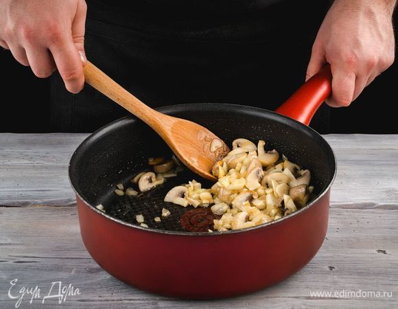 В глубокой сковороде разогрейте оливковое масло, обжарьте лук до прозрачности, добавьте чеснок и грибы. Пожарьте до готовности грибов.
