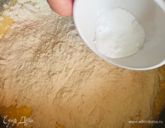 Добавляем муку, а поверх муки — соду, тщательно вымешиваем руками. Тесто должно прилипать к рукам.