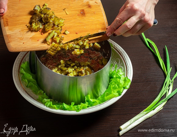 Положите маринованный огурец и слой майонеза.