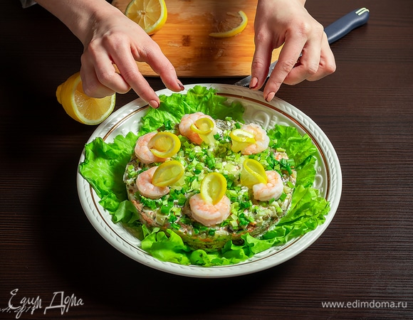 Креветки почистите. Отварите в кисло-соленой воде минуты 3–4. Соорудите из них и лимона узор, который вам подскажет фантазия.