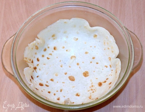 Формируем курник. Берем круглую форму для выпечки, смазываем маслом, на дно кладем 1 блин.